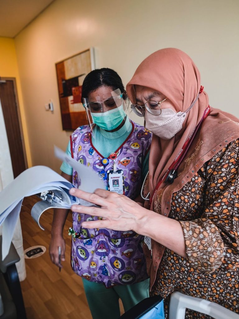 Oncologist Doctor Eni checking in on patient's documents with a fellow nurse